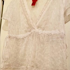 Sheer blouse designed with floral embroidered detail & adjustable sides.